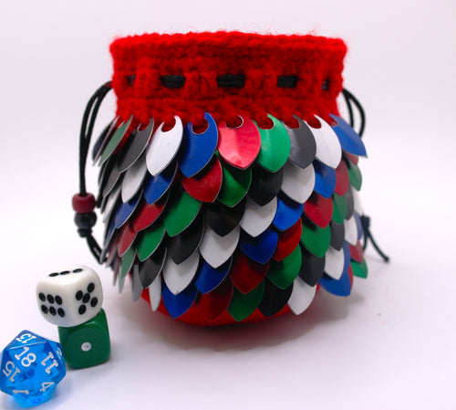 Dice bag representing Tiamat made from red yarn with red, blue, white, black, and green metallic dragon scales with a black drawstring closure.