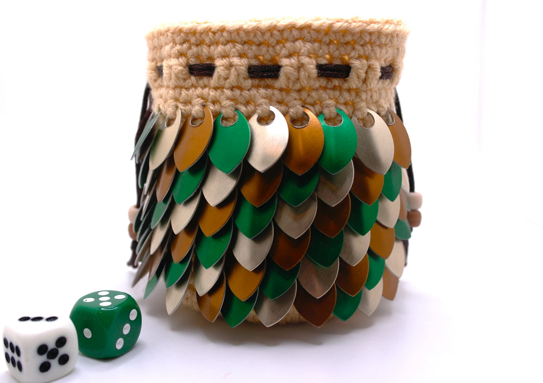 Dice bag made from beige yarn with green, brown, and champagne metallic scales with a brown drawstring closure